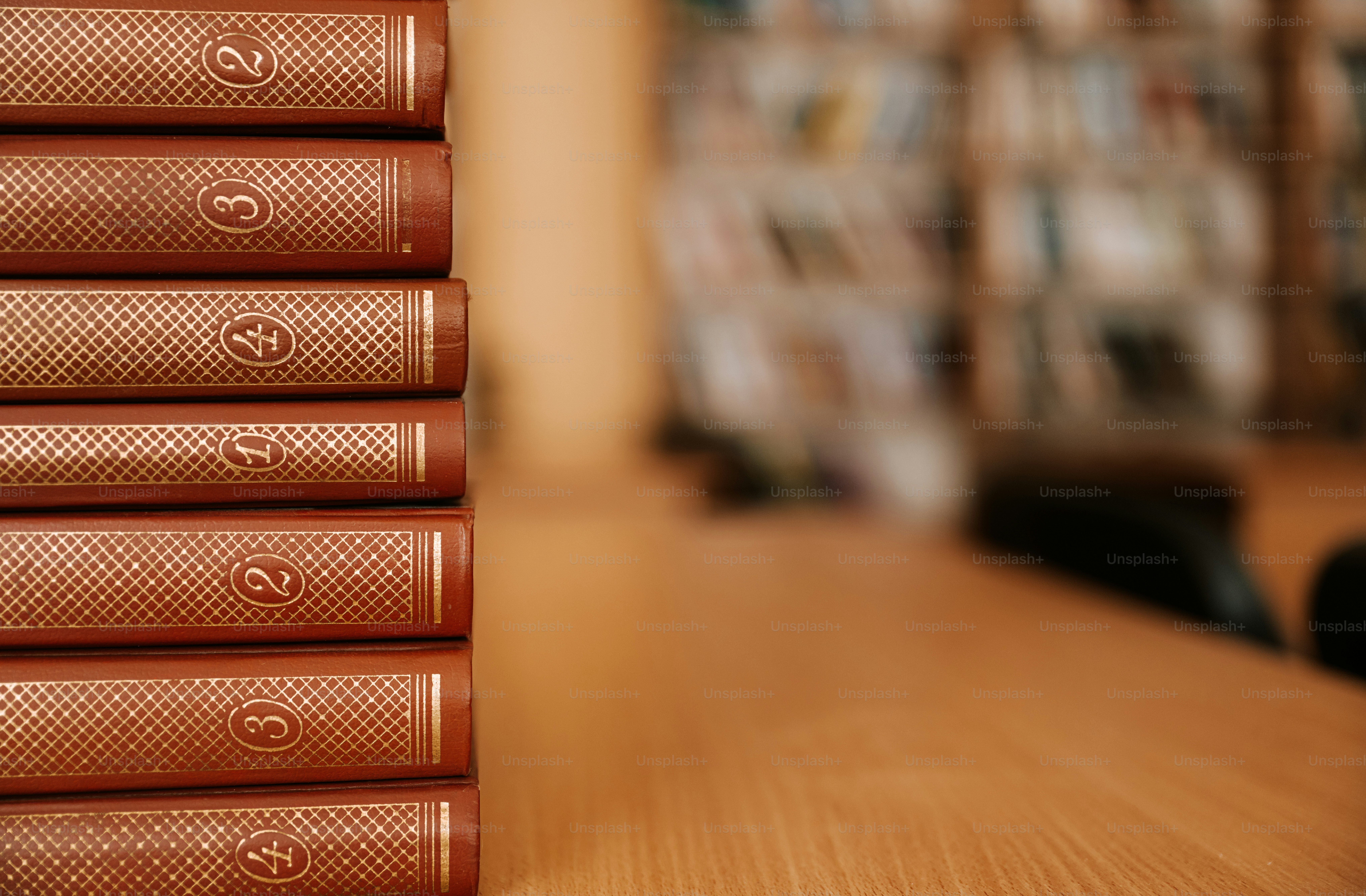 A stack of books on a wooden table.